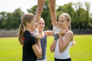 Teilnehmerinnen beim Training von Hebefiguren im Ferienkurs der Munich Cowboys Cheerleader – ein Ferienangebot für jedes Alter.